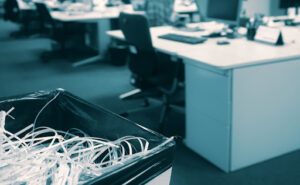 A trash can filled with paper shreds sits open in an office. As digital documents become the norm, businesses must continue to be vigilant about both physical and digital data security.